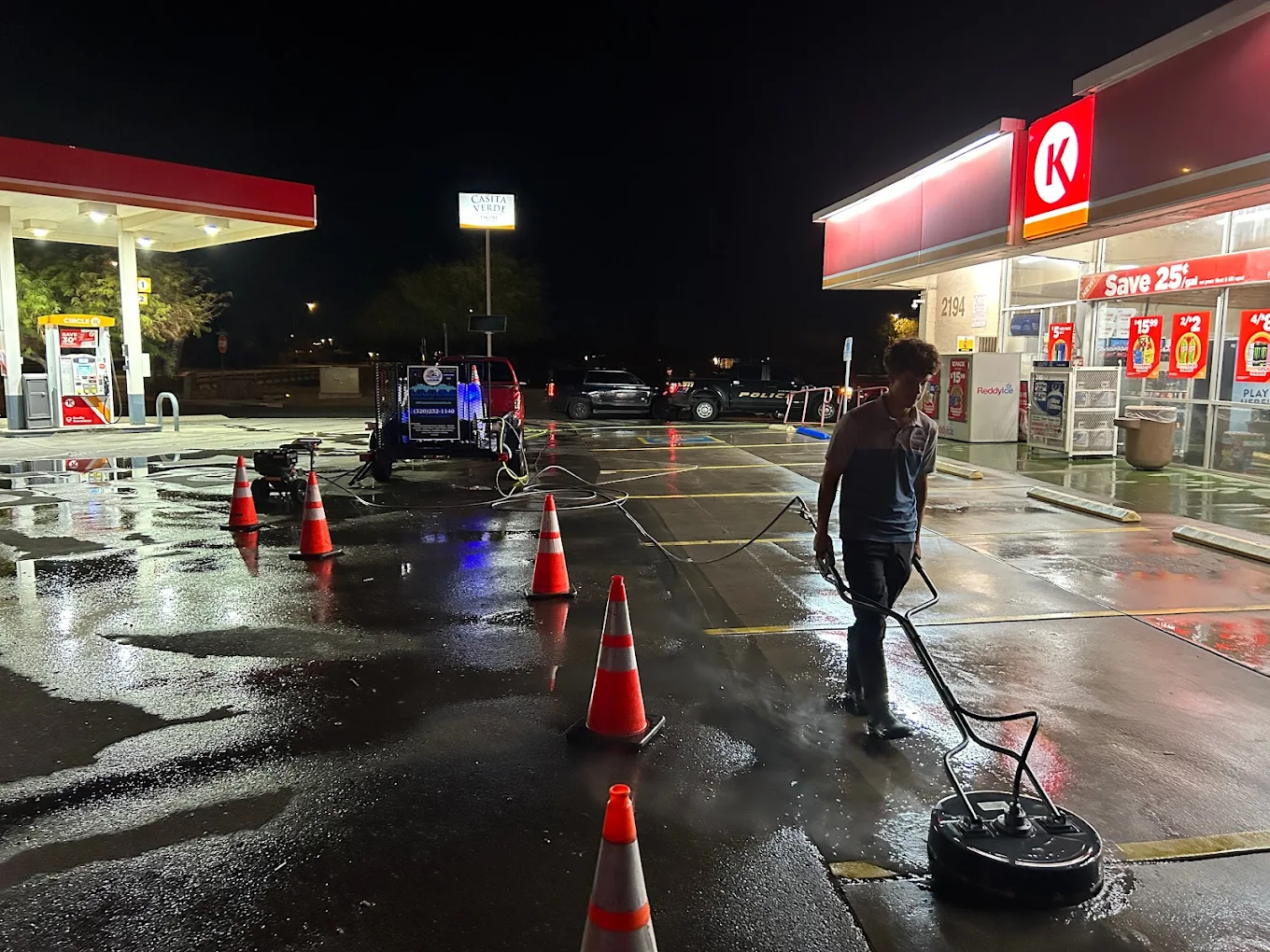 Commercial gas station parking lot power washing at night